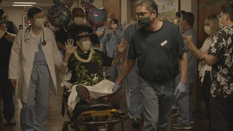 Wearing maile, pikake, and his signature black hat, Jack Denis waved to the hospital staff who...