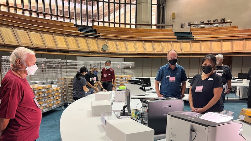 Election workers and observers oversee ballot machines at State Capitol.