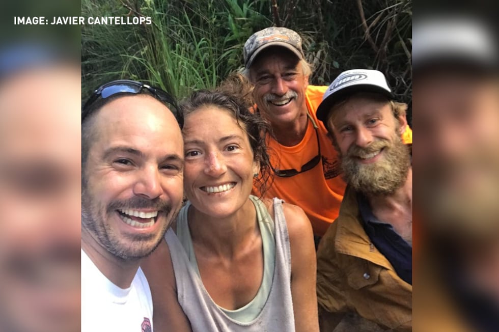 Rescuers pose with Amanda Eller after finding her alive in the Maui mountains, more than two...
