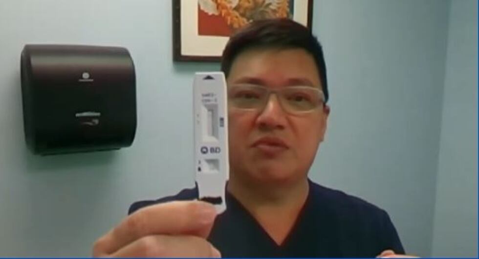 Dr. Alan Wu holds up a quidel, antigen test