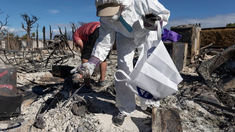 Debbie Patton and homeowner Steve Lawless search for personal effects at their property on...