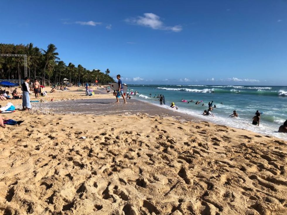 Beach-goers see the effects of the king tides on Waikiki Beach as the water flows onto the sand.