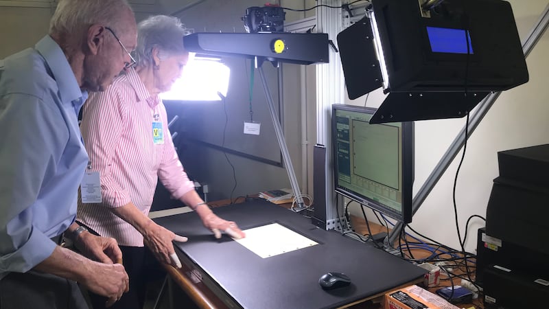 Volunteers David and Phyllis Walch photograph tax records.
