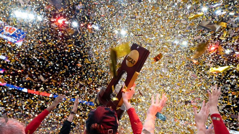 Wisconsin players hold up the NCAA trophy after defeating Nebraska in the championship match...