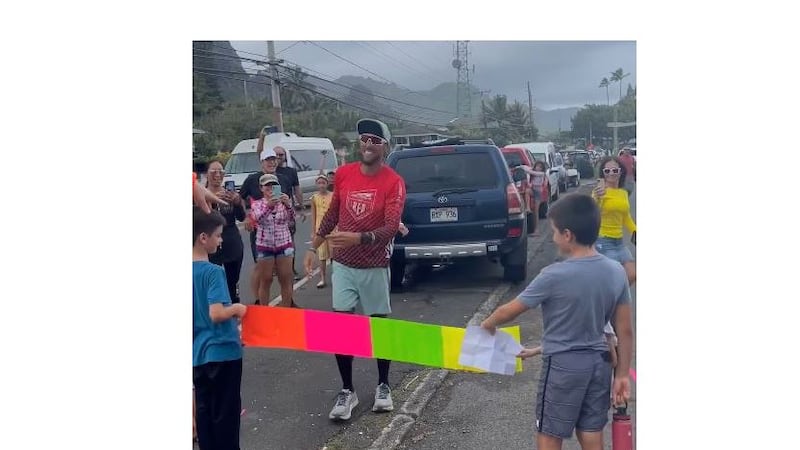 He crossed the finish line surrounded by friends and supporters.