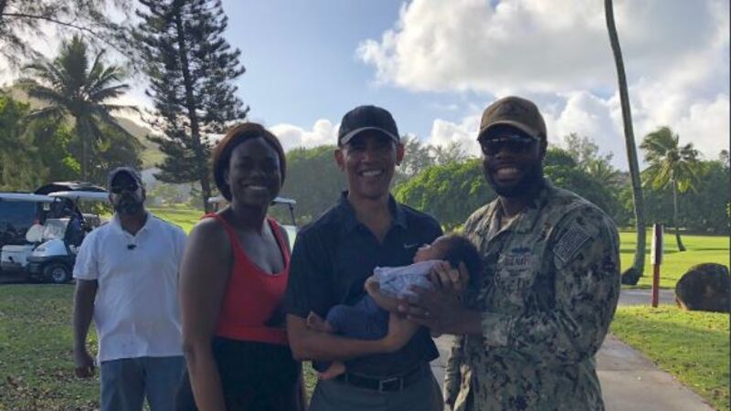 Former President Obama carried baby Riley while at an Oahu golf course.