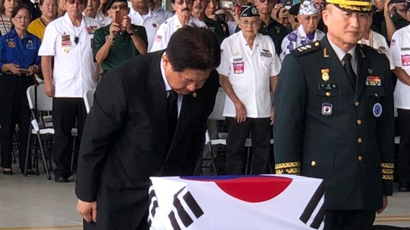 Choo Suk Suh, South Korea's Vice Minister of National Defense, bows before a box holding...