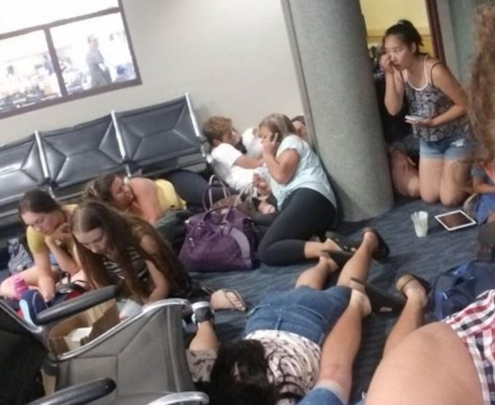 Passengers huddled on the floor during a false security scare at Honolulu's airport. (Image:...